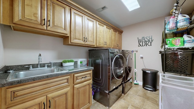 washroom featuring cabinet space, baseboards, a sink, and washing machine and clothes dryer