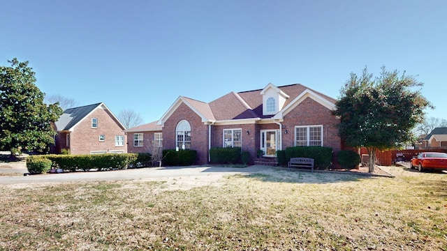 view of front of house with a front yard, fence, and brick siding