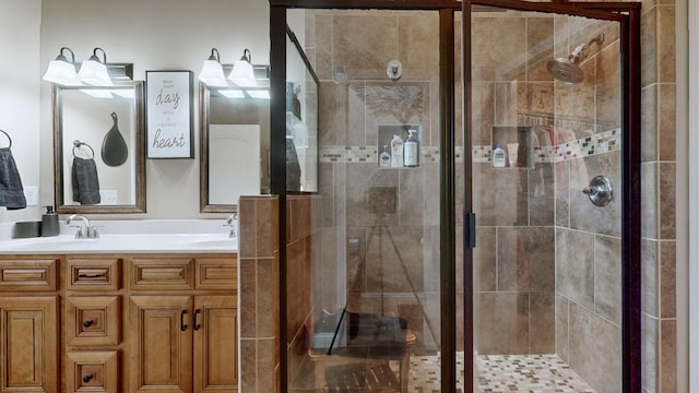 full bath with a sink, a shower stall, and double vanity