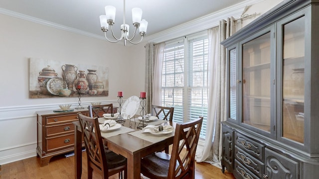 dining area featuring a chandelier, crown molding, and light wood-style flooring