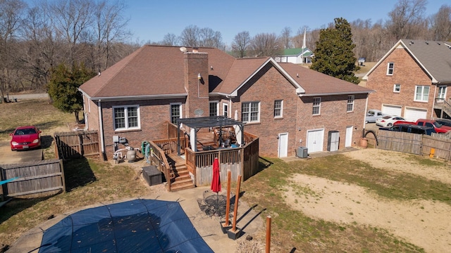 rear view of property with a deck, a fenced backyard, a chimney, and central AC unit