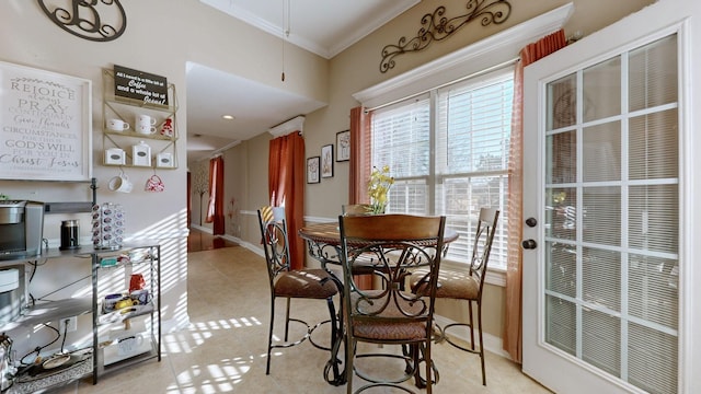 dining area with crown molding, baseboards, and light tile patterned floors