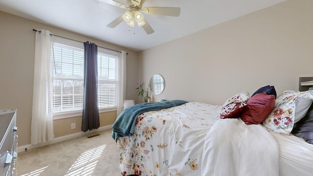 bedroom featuring light carpet, baseboards, visible vents, and a ceiling fan