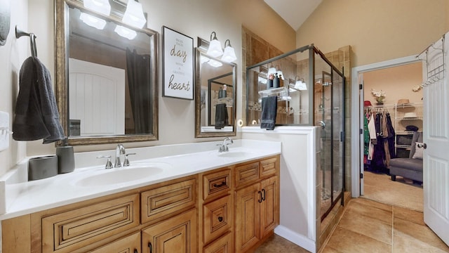 full bathroom featuring tile patterned flooring, a sink, a shower stall, and double vanity