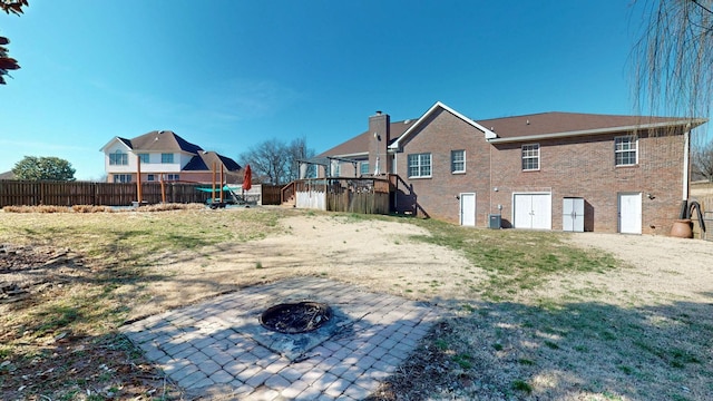 exterior space with an outdoor fire pit, central air condition unit, fence, a wooden deck, and a patio area