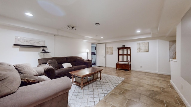 living area with a tray ceiling, recessed lighting, and baseboards