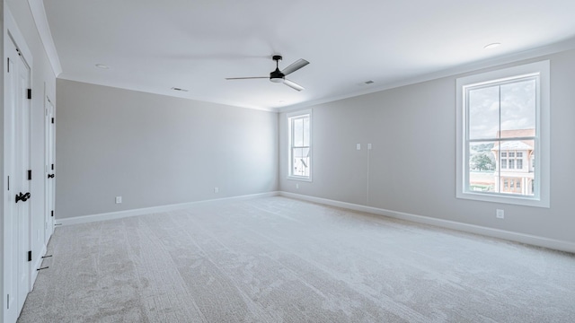 spare room featuring light carpet, baseboards, and crown molding