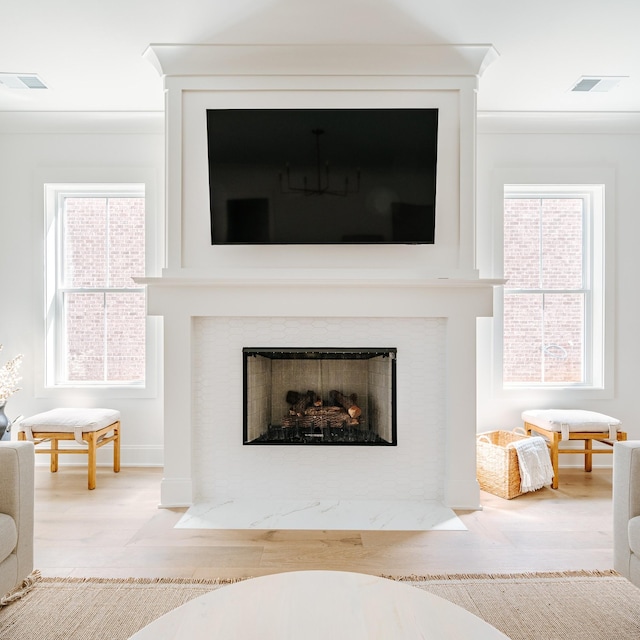 details with visible vents, a fireplace, and wood finished floors