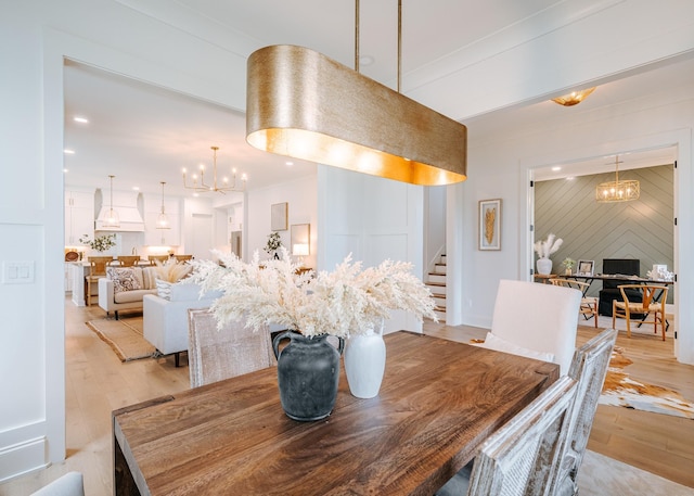 dining area featuring light wood-type flooring, stairs, a chandelier, and recessed lighting