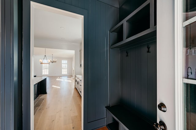 mudroom featuring a chandelier, ornamental molding, and light wood-style flooring