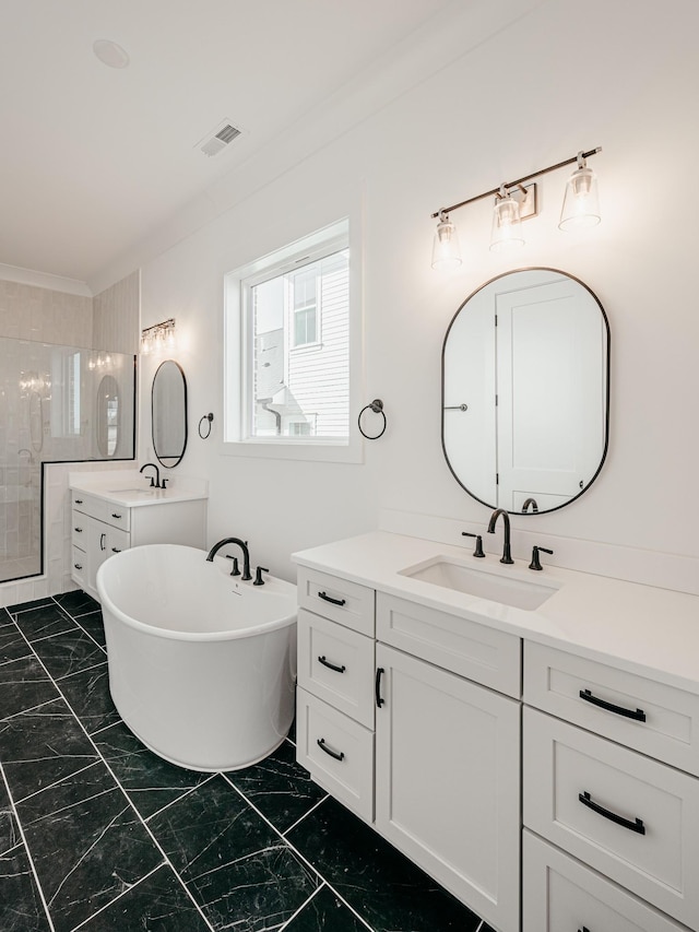 bathroom featuring a freestanding tub, two vanities, a sink, visible vents, and marble finish floor