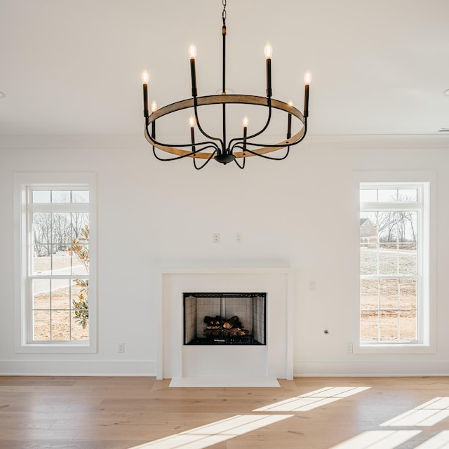 room details featuring a fireplace with flush hearth, crown molding, baseboards, and wood finished floors