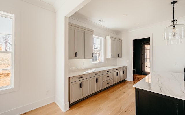 kitchen with light wood-style floors, tasteful backsplash, baseboards, and crown molding