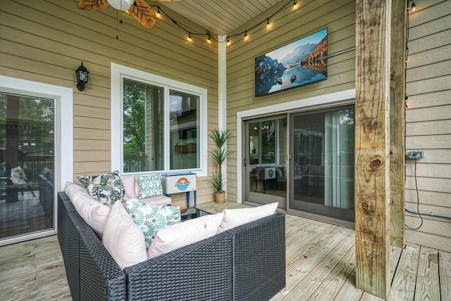 wooden terrace featuring an outdoor living space and a ceiling fan