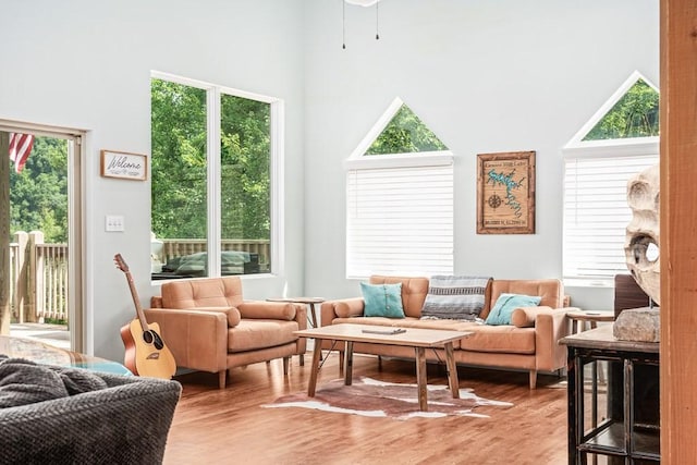 sitting room with a towering ceiling and light wood-style flooring