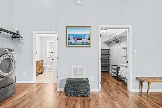 clothes washing area with laundry area, visible vents, wood finished floors, and washer / dryer