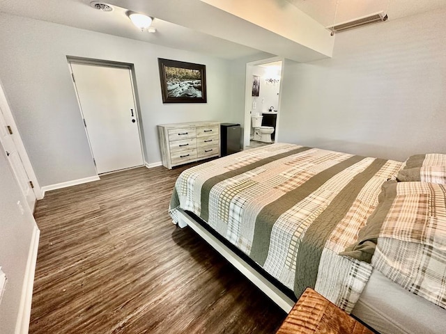 bedroom featuring visible vents, baseboards, and wood finished floors