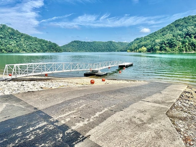 view of dock featuring a water view and a wooded view