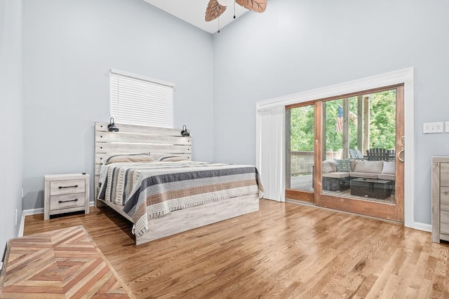 bedroom featuring access to outside, wood finished floors, a ceiling fan, and baseboards