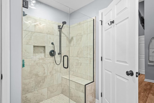 bathroom with a stall shower and wood finished floors