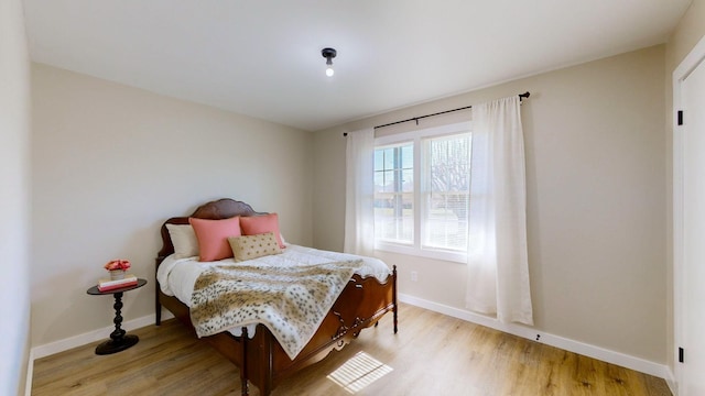 bedroom with light wood-type flooring and baseboards