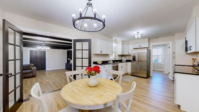 dining area with baseboards, light wood-style flooring, and an inviting chandelier