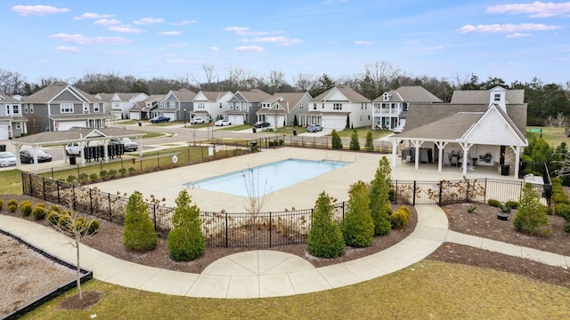 pool featuring a residential view, a patio area, and fence