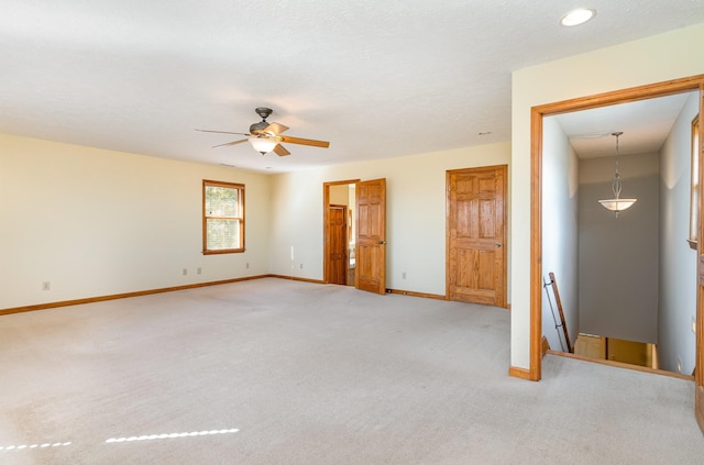 unfurnished bedroom featuring ceiling fan, baseboards, and light colored carpet