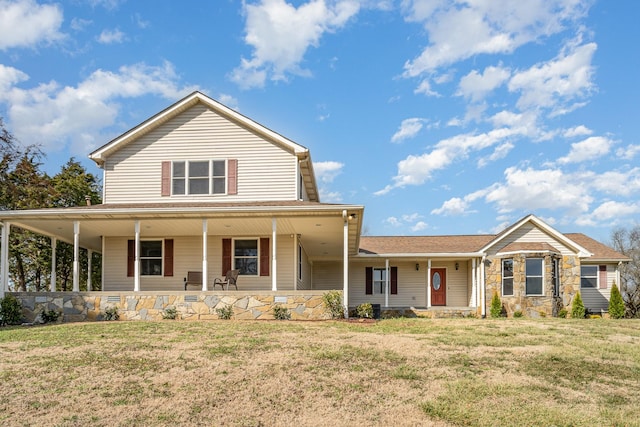 country-style home with covered porch, stone siding, and a front yard