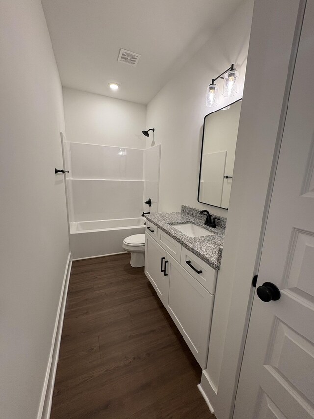 full bath with bathing tub / shower combination, visible vents, toilet, vanity, and wood finished floors