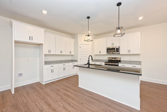 kitchen featuring a sink, stainless steel appliances, light wood-style floors, and white cabinets