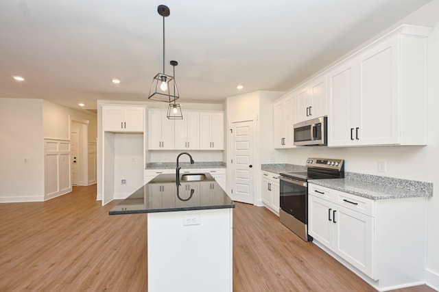 kitchen featuring recessed lighting, stainless steel appliances, light wood-style floors, and a sink