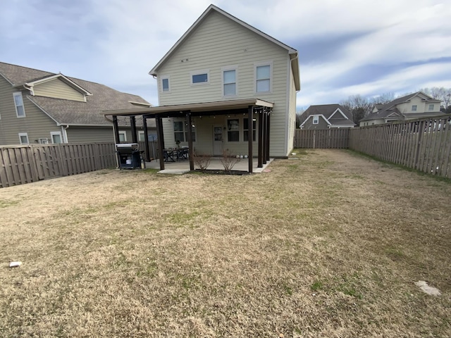 back of house featuring a patio area, a yard, and a fenced backyard