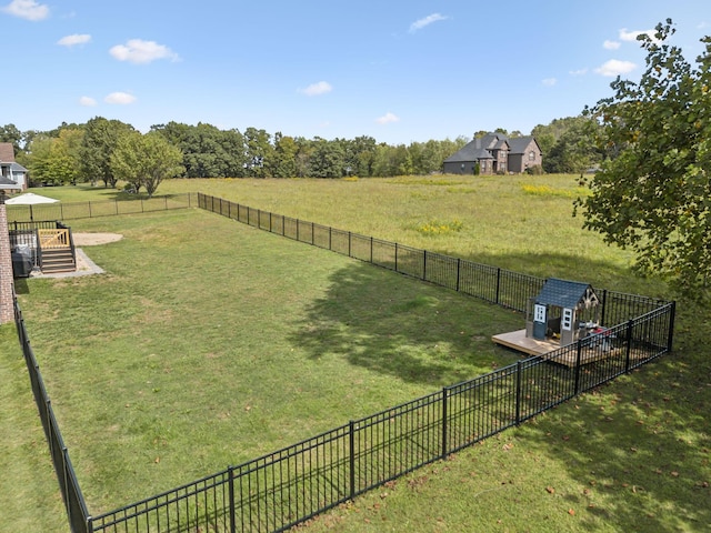 view of yard with an outbuilding, a fenced backyard, and a rural view