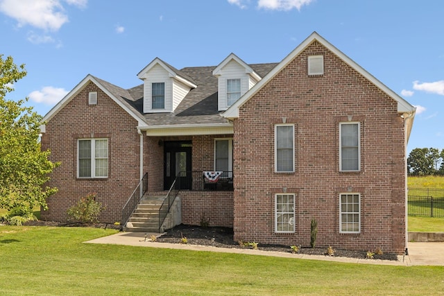 view of front of home featuring fence, a front lawn, and brick siding