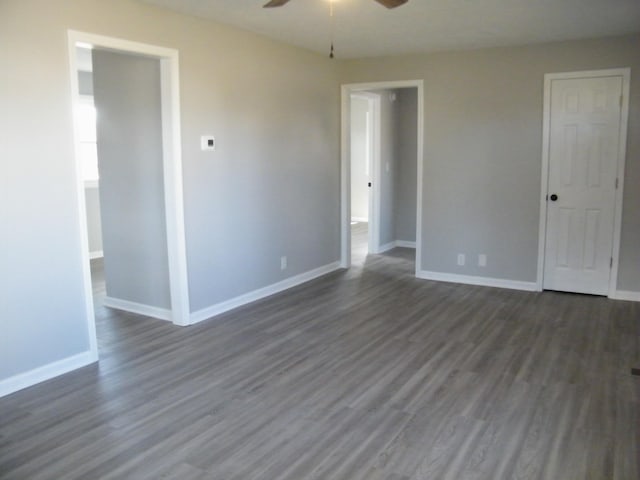 unfurnished bedroom featuring a ceiling fan, baseboards, and dark wood-style flooring