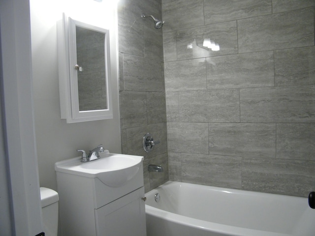 bathroom featuring toilet, tub / shower combination, and vanity