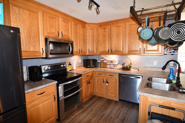 kitchen with dark wood-style floors, appliances with stainless steel finishes, light countertops, and a sink