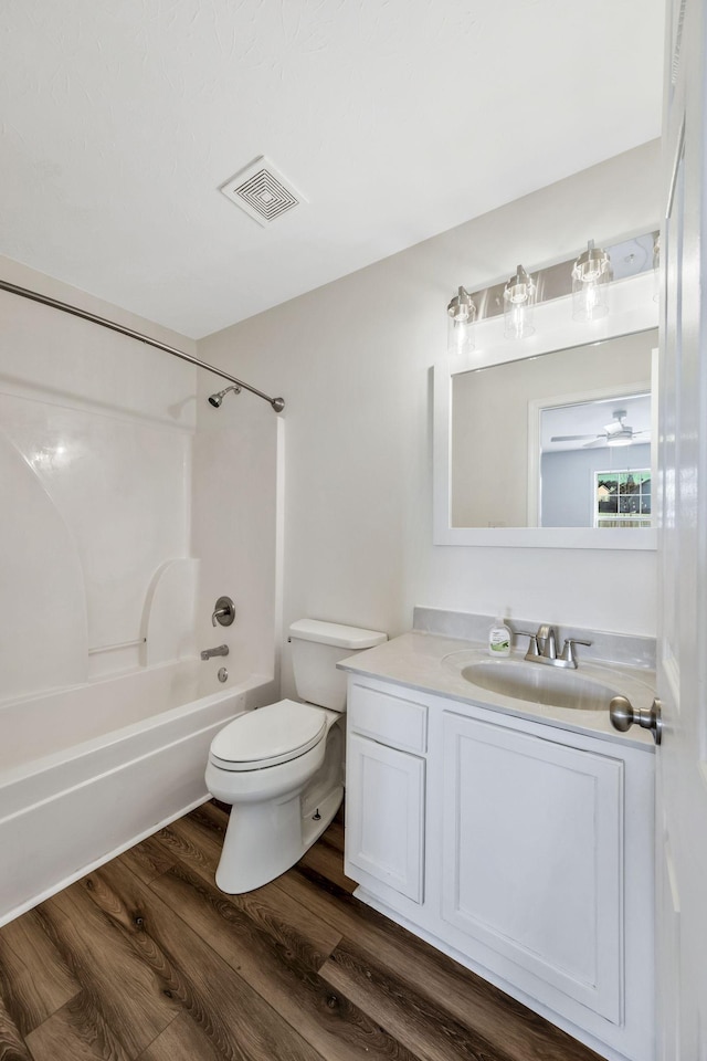 bathroom with shower / bathtub combination, visible vents, toilet, vanity, and wood finished floors