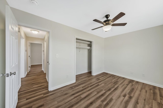 unfurnished bedroom featuring ceiling fan, a closet, wood finished floors, and baseboards