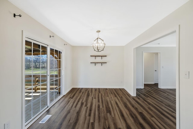 unfurnished dining area featuring an inviting chandelier, baseboards, and dark wood-style flooring