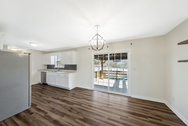 kitchen with dark wood-style flooring, stainless steel appliances, light countertops, white cabinets, and a sink