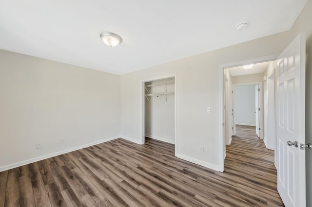 unfurnished bedroom with a closet, baseboards, and wood finished floors