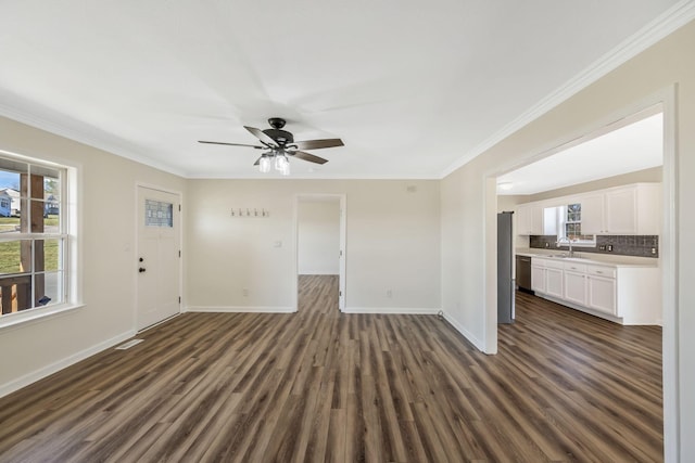 unfurnished living room with baseboards, ceiling fan, dark wood-style flooring, crown molding, and a sink