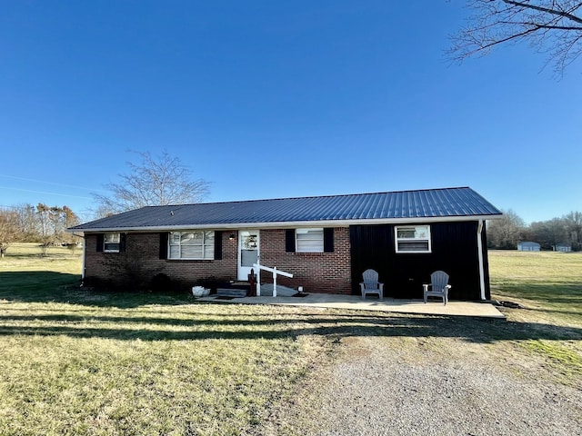 view of front of property featuring metal roof and a front lawn