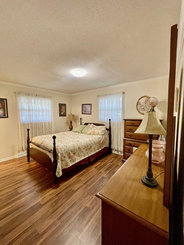 bedroom with ornamental molding, multiple windows, and wood finished floors