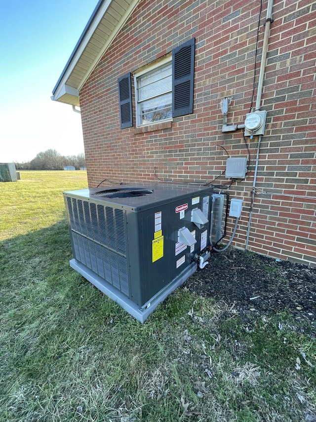 exterior details featuring central AC, brick siding, and electric meter