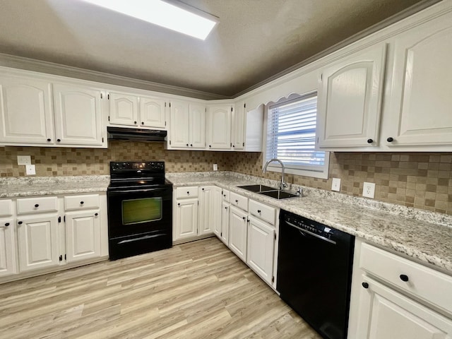 kitchen with light wood finished floors, under cabinet range hood, black appliances, white cabinetry, and a sink