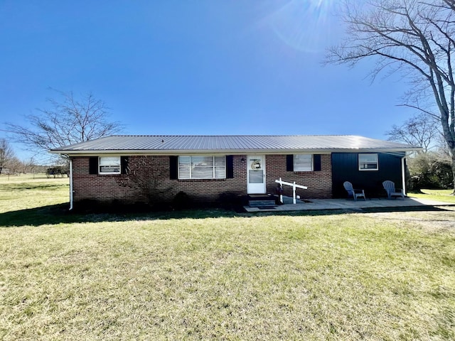 single story home featuring entry steps, a front lawn, and brick siding