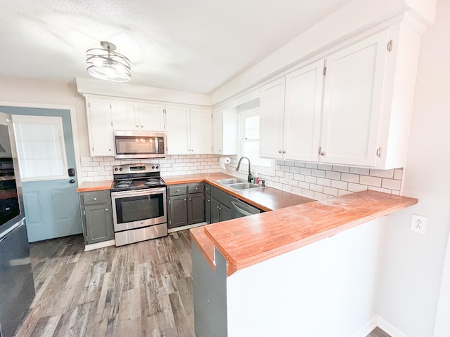 kitchen featuring a sink, white cabinetry, appliances with stainless steel finishes, gray cabinets, and light wood finished floors